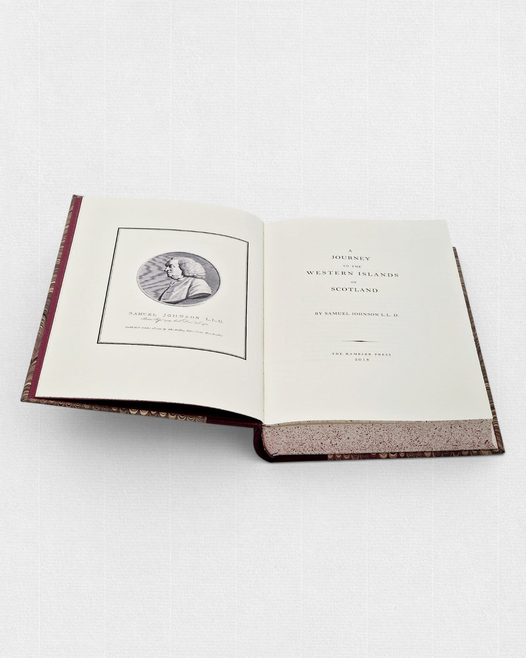 Otwarta książka „A Journey to the Western Islands of Scotland” autorstwa Samuela Johnsona; po lewej stronie widoczny portret autora, po prawej strona tytułowa, z bordową oprawą i jasnymi, nakrapianymi brzegami stron.