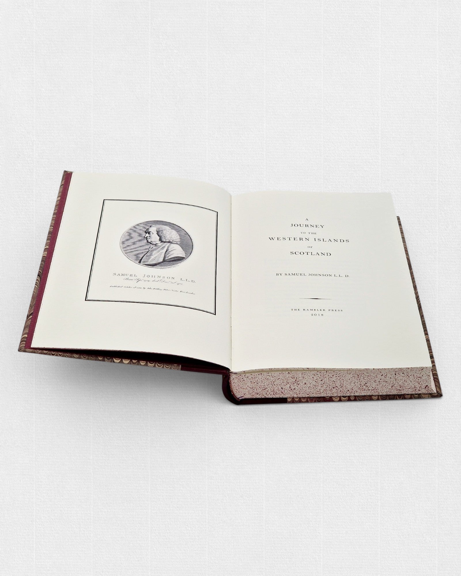 Otwarta książka „A Journey to the Western Islands of Scotland” autorstwa Samuela Johnsona; po lewej stronie widoczny portret autora, po prawej strona tytułowa, z bordową oprawą i jasnymi, nakrapianymi brzegami stron.