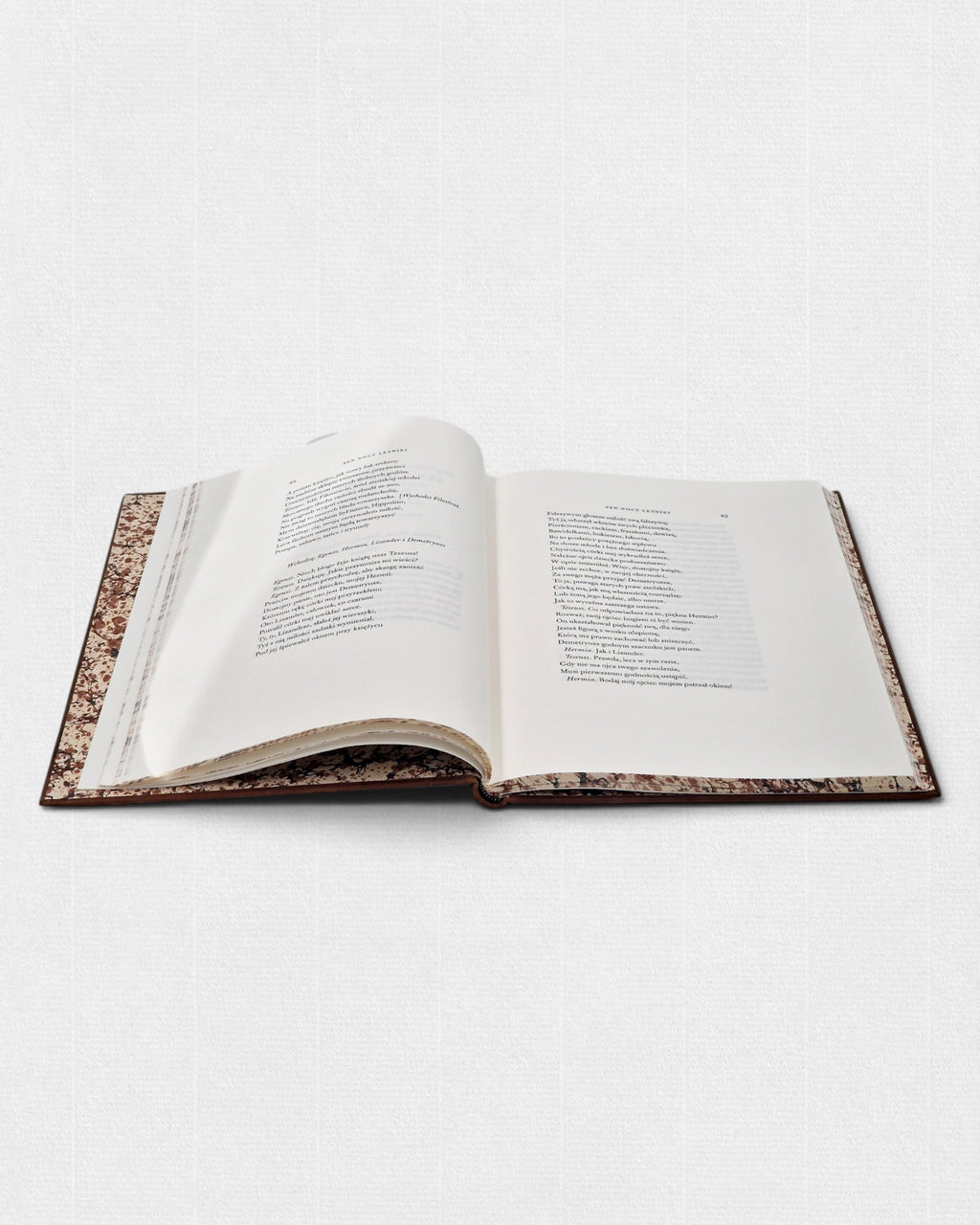 Otwarte wydanie Snu nocy letniej Williama Shakespeare’a z widocznym składem tekstu, oprawione ręcznie z wyklejką z papieru marmurkowego.