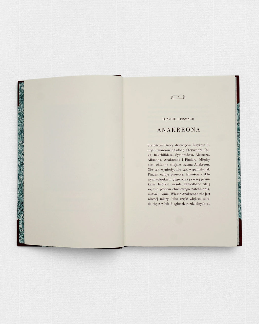 Rozkładówka kolekcjonerskiego wydania „Pieśni Anakreonta” w tłumaczeniu Brunona Kicińskiego, przygotowanego przez Rambler Press. Widoczny klasycystyczny skład typograficzny krojem LTC Bodoni, szerokie marginesy oraz spokojny układ strony inspirowany europejską książką XIX wieku. Ręcznie oprawiona książka bibliofilska wydrukowana na żeberkowym papierze Century Laid z filigranem.