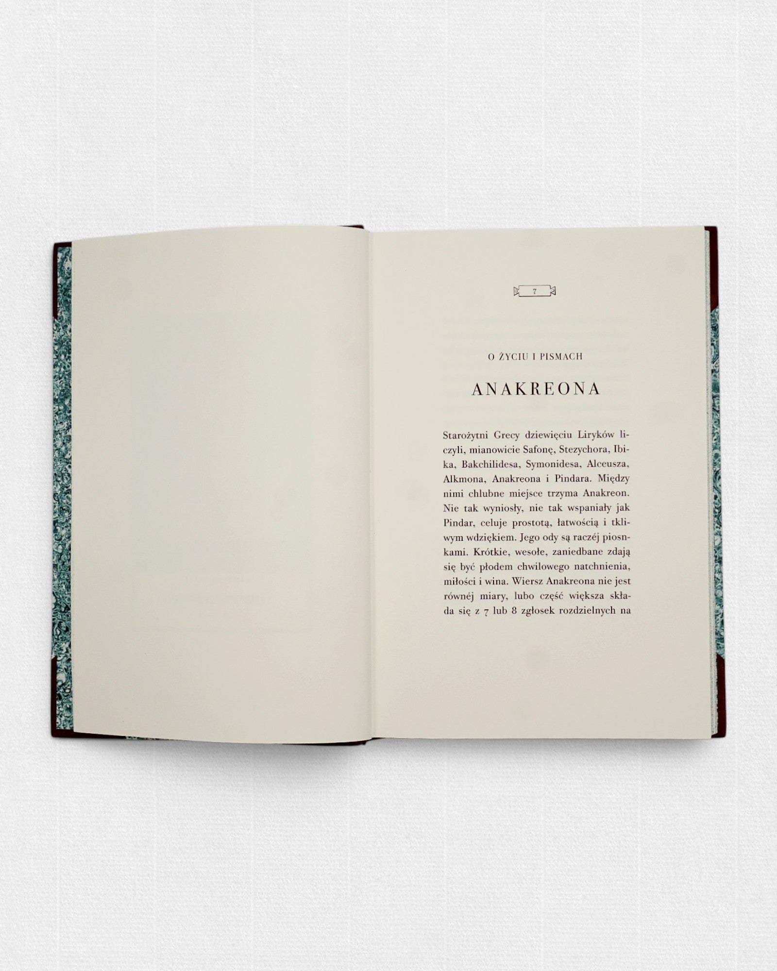 Rozkładówka kolekcjonerskiego wydania „Pieśni Anakreonta” w tłumaczeniu Brunona Kicińskiego, przygotowanego przez Rambler Press. Widoczny klasycystyczny skład typograficzny krojem LTC Bodoni, szerokie marginesy oraz spokojny układ strony inspirowany europejską książką XIX wieku. Ręcznie oprawiona książka bibliofilska wydrukowana na żeberkowym papierze Century Laid z filigranem.