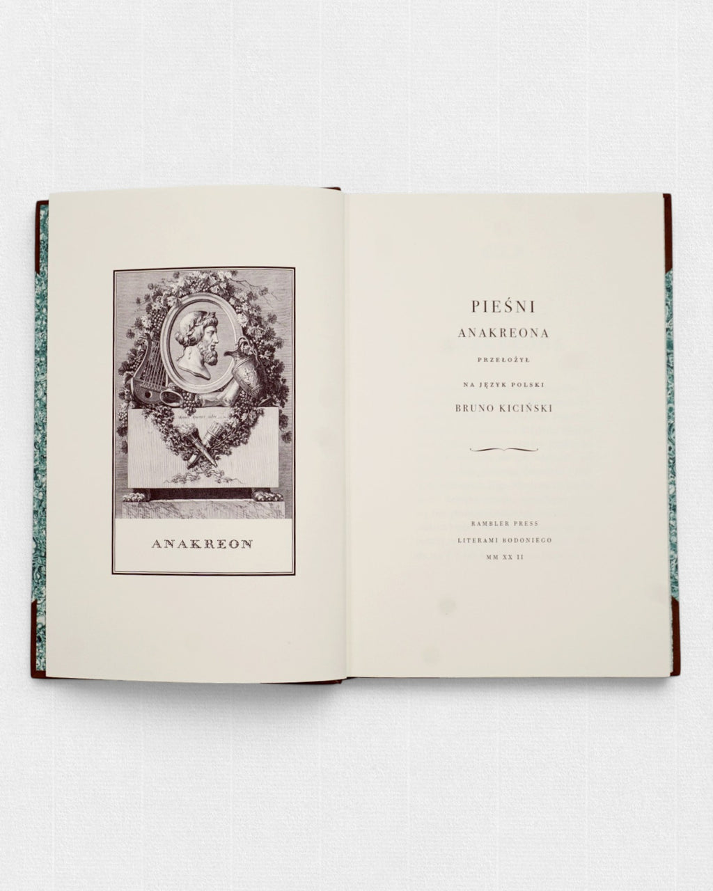 Strona tytułowa kolekcjonerskiego wydania „Pieśni Anakreonta” w tłumaczeniu Brunona Kicińskiego, przygotowanego przez Rambler Press. Widoczna klasycystyczna typografia złożona krojem LTC Bodoni oraz ilustracja inspirowana francuskimi wydaniami Pierre’a Didota z końca XVIII wieku. Ręcznie oprawiona książka bibliofilska wydrukowana na bawełnianym papierze Century Laid.