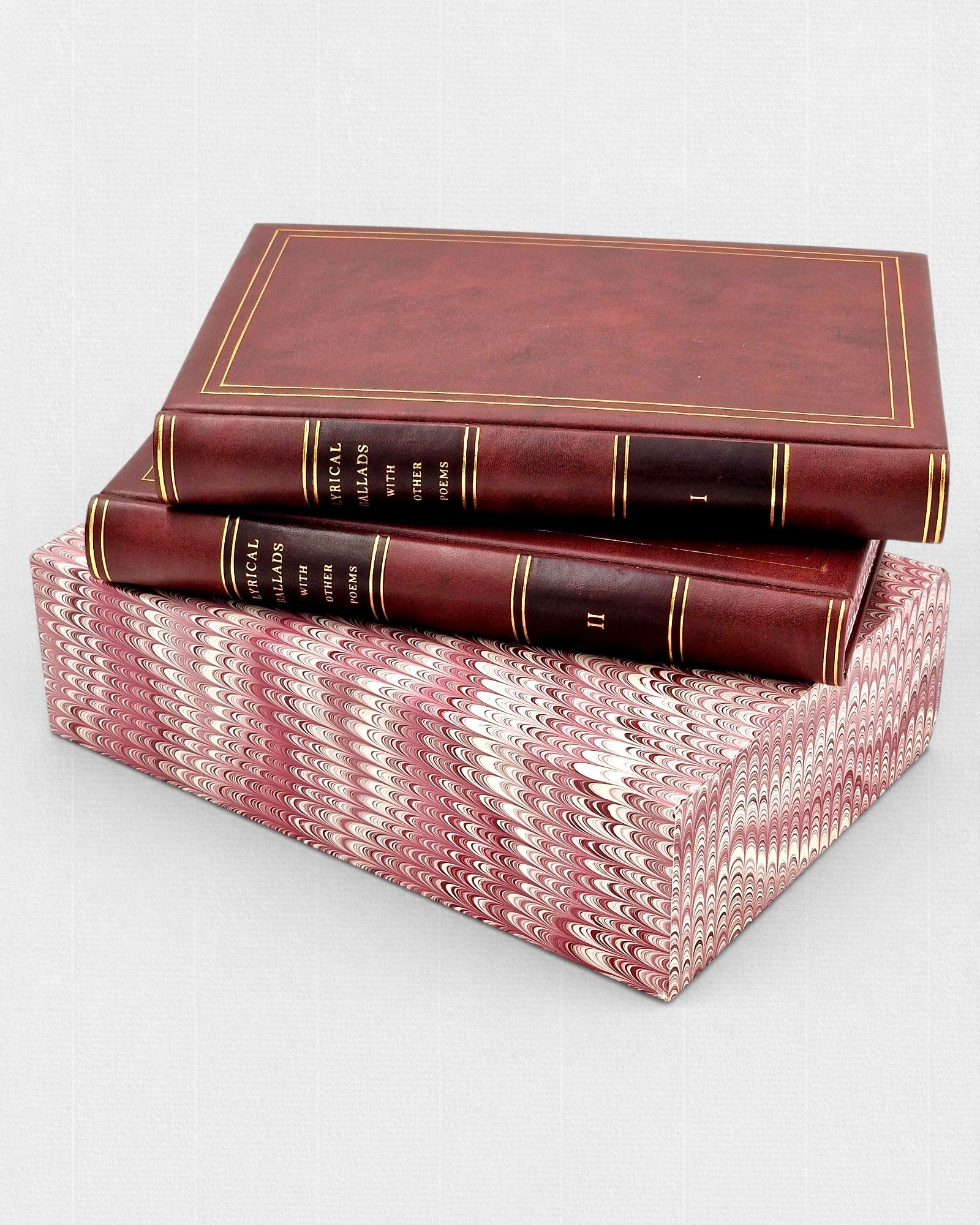 Dwa tomy „Lyrical Ballads with Other Poems” Williama Wordswortha w skórzanej oprawie ze złoceniami, ułożone na marmoryzowanym etui.